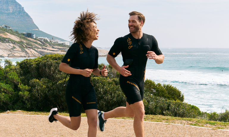 Zwei Personen beim EMS-Training im Freien mit Blick auf das Wasser